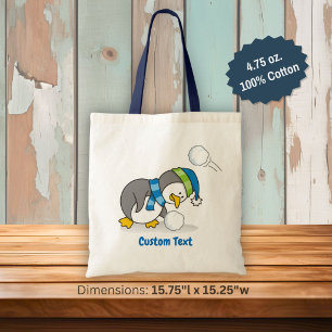 Little penguin getting a snow ball tote bag
