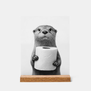 Loutre stoïque tenant un rouleau de papier toilett