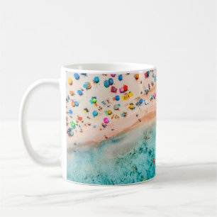 Luftblick auf den Sandstrand mit bunten Regenschir Kaffeetasse