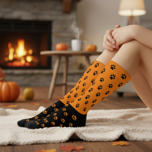 Lustige orange und schwarze Socken mit Pfotenabdru