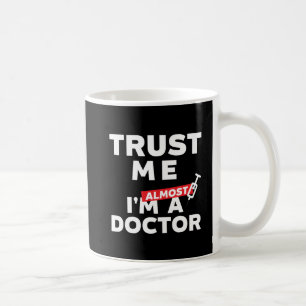 Lustiger Medizinstudent vertrauen, dass ich ich Kaffeetasse