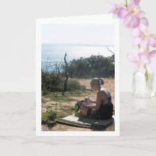 Mädchen liest am Strand Karte
