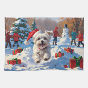 Malteser Hund läuft im Schnee mit Weihnachtshut Geschirrtuch