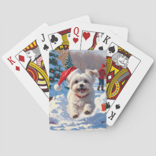Malteserhund läuft im Schnee mit Weihnachtsmütze Spielkarten