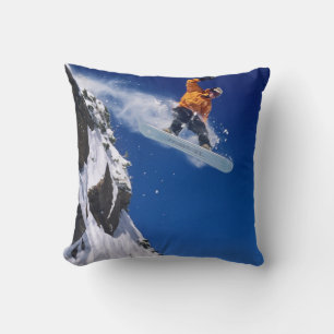 Mann auf einem Snowboard, der von einem Gesims spr Kissen