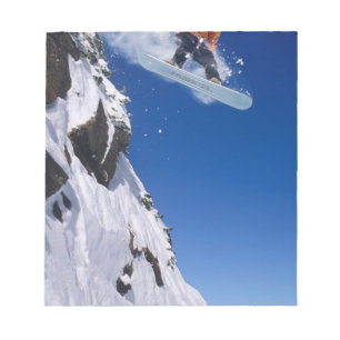 Mann auf einem Snowboard, der von einem Gesims spr Notizblock