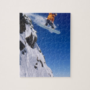 Mann auf einem Snowboard, der von einer Gesimskant