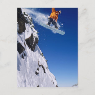 Mann auf einem Snowboard springt von einem Kornfle Postkarte