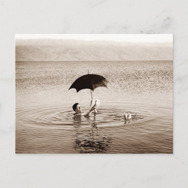 Mann, der unter einem Regenschirm im Toten Meer li Postkarte (Vorderseite)