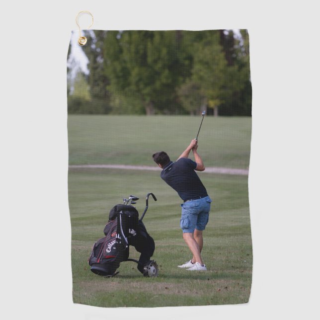 Mann schwingt die Handtücher eines Golfklubs (Vorderseite)