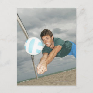 Mann spielt Volleyball am Strand Postkarte