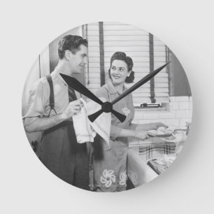 Mann und Frau, die Geschirr tun Runde Wanduhr