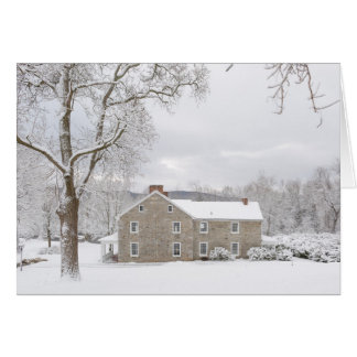 Manoir en pierre dans la neige avec des collines