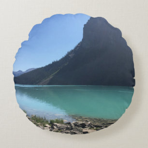 MEHRFARBIGE KANUS AM STEG IN EINEM SEE VERTÄUT RUNDES KISSEN