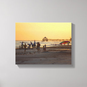 Menschen am Strand bei Sonnenuntergang Leinwanddruck