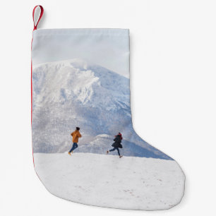 Menschen, die Spaß haben und in den Bergen laufen Kleiner Weihnachtsstrumpf