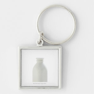 Milchflasche auf weißem Hintergrund Schlüsselanhänger