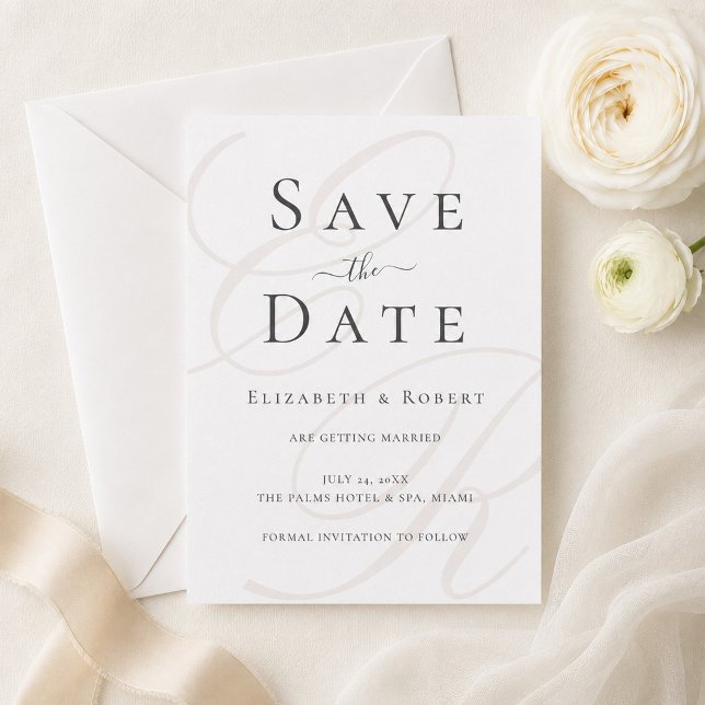 Minimalistische Beige Monogram Wedding Save the Da Date (Minimalist Monogram Save the Date Card on a table with white flowers and a silk ribbon)