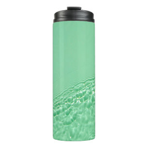 Minzblau gefärbte klare Wasseroberflächentextur mi Thermosbecher