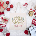 Modern Gold Script Frohe Weihnachten Individuelle  Tragetasche<br><div class="desc">Stilvolle Weihnachtsstuben mit festlich grünen Zweigen von heiligen Blätter und roten Beeren prägen das moderne antike goldene Drehbuch-Design. Der benutzerdefinierte Text in Monogramm kann ein Name oder ein anderer Text personalisiert werden.</div>