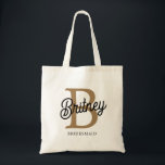 Modern Monogram Name Black Gold Script Bridesmaid Tragetasche<br><div class="desc">Die moderne elegante Monogram Name Black Gold Script Tote Tasche kombiniert Eleganz mit Praxisnähe. Diese Tasche zeichnet sich durch einen schlichten, schwarzen Stoff aus, der mit einer eleganten goldenen Schriftzeichen-Monogrammatisierung verziert ist, was sie sowohl stilvoll als auch personalisiert macht. Das geräumige Interieur eignet sich perfekt für den Alltag, während die...</div>
