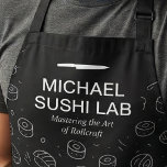 Modern Sushi Pattern with Chef Name Unique Schürze<br><div class="desc">This design features a sleek black background filled with hand-drawn sushi icons in a clean line art style. Bold white typography highlights a culinary studio theme, paired with a minimalist knife graphic and an elegant subtitle for a polished, professional look. The monochrome palette gives it a modern, upscale feel that...</div>
