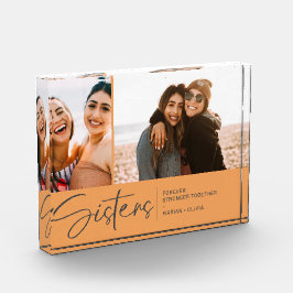 Moderne Schwestern halten zwei Fotos in blass oran