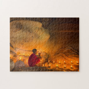 Mönch betend neben einem Buddha