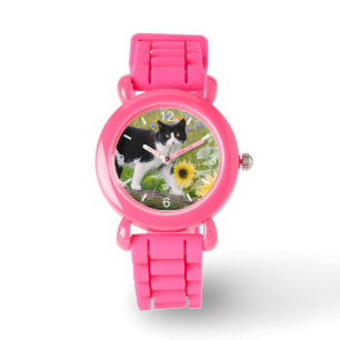 Montre Un mignon chat tuxedo sur une branche d'arbre avec