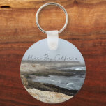 Morro Bay California Coastal Photography Schlüsselanhänger<br><div class="desc">A foggy overcast day in Morro Bay California with the ocean waves hitting the rocks on the shore in this beach photograph souvenir. This seaside travel photo keepsake keychain features black cursive script above the beach rocks and grey sky.</div>