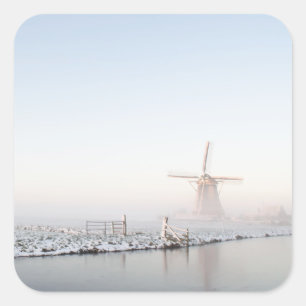 Moulin à vent dans la neige en hiver autocollant