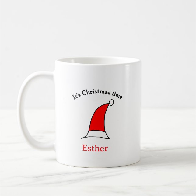 Mug C'est Noël heure Père Noël rouge casquette nom sim (Gauche)