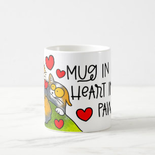 Mug cogner dans les mains dans ses pattes