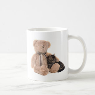 Mug kitten in the arms of a teddy bear