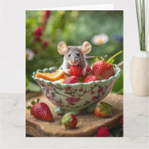 Muis geniet van een aardbei in een schaaltje fruit