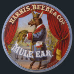 Mule Oar Tobacco Label Button<br><div class="desc">Tabaketikett, auf dem ein auf den Hinterbeinen stehendes Maultier in voller Länge dargestellt wird, das Kleid und die Brille trägt und Tabak-Blätter trägt. Harris, Beebe & Cos., erstellt von The Hatch Lithography Co., 1868</div>
