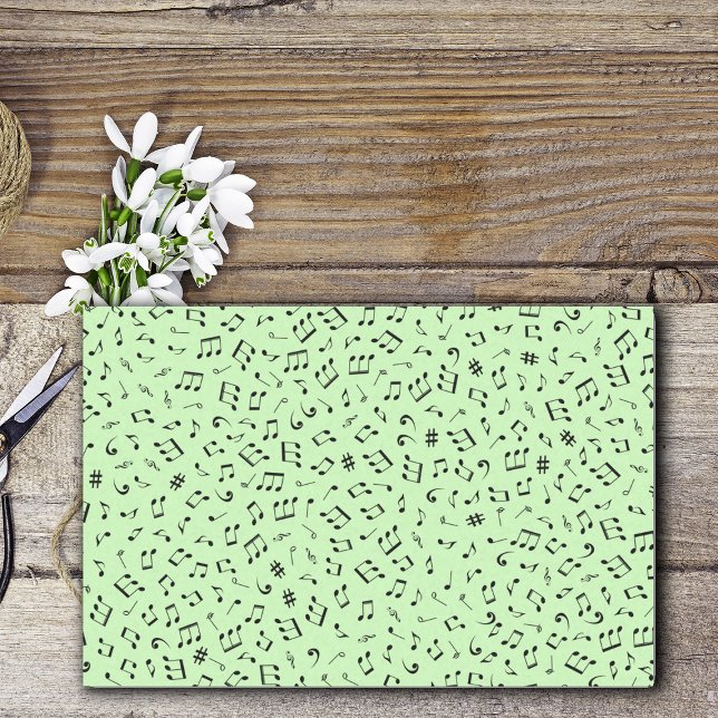 Musikalisches Thema Verschiedene Schwarze Musiknot Seidenpapier (variety of different black music notes on light green gift wrapping tissue paper sheets.)