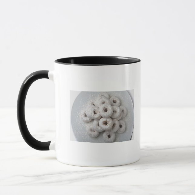 Nahaufnahme der pulverisierten Krapfen in einer Tasse (Links)