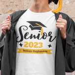 Name des Abschlusses der höheren Klasse T-Shirt<br><div class="desc">Feiern Sie Ihr Senior- und Abschluss-Jahr mit diesem modernen T - Shirt mit einer zeitgenössischen "Senior 20xx" Typografie in Schwarz und Gold dekoriert mit einem schwarzen Graduierenkappe mit einem goldenen Tassel; leicht anpassen Sie diesen T - Shirt mit Ihrem Abschluss Jahr und Namen durch die Bearbeitung der Vorlagenfelder. Dieser T...</div>