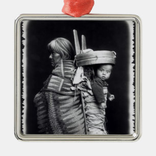 Navajofrau, die ein papoose auf ihr zurückbringt silbernes ornament