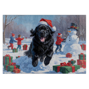 Neufundländer läuft im Schnee mit Weihnachtsmütze Schneidebrett