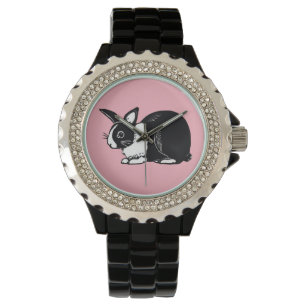 Niederländisches Schwarzweiss-Kaninchen mit rosa Armbanduhr