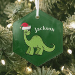 Niedlich Kids Christmas Dinosaurier Green Personal Ornament Aus Glas<br><div class="desc">Phantastischer grüner Dinosaurier lächelt und sieht sehr niedlich in einem Urlaub roten Weihnachtsmannmütze. Ich mag prähistorische Weihnachtstiere und Geschenke,  die Kinder Liebe. Passen Sie dieses Geschenk mit dem Namen des Empfängers an,  um es noch personalisierter zu machen.</div>