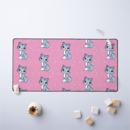 Niedliche blaue Katze auf rosa Schreibtischunterlage
