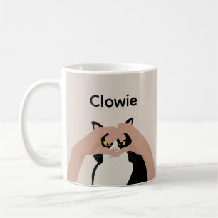 Niedliche Creme Schwarz-weiße Katzenherz Hände kun Kaffeetasse