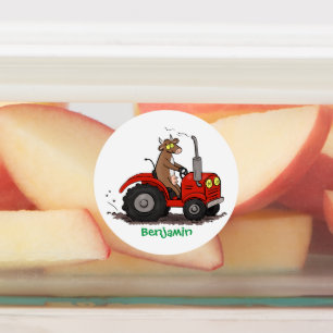 Niedliche glückliche Kuh, die einen roten Traktor- Etiketten