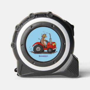 Niedliche glückliche Kuh, die einen roten Traktor- Maßband