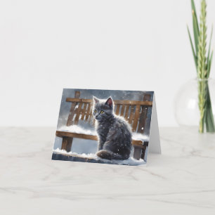 Niedliche graue Katze auf Bank im Schneewinter Gru Karte