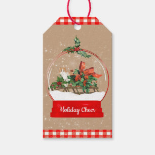 Niedliche Katze auf einem Schlittenschneedecker mi Geschenkanhänger
