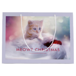 Niedliche Kittenruhe auf einer Weihnachtsmannmütze Große Geschenktüte